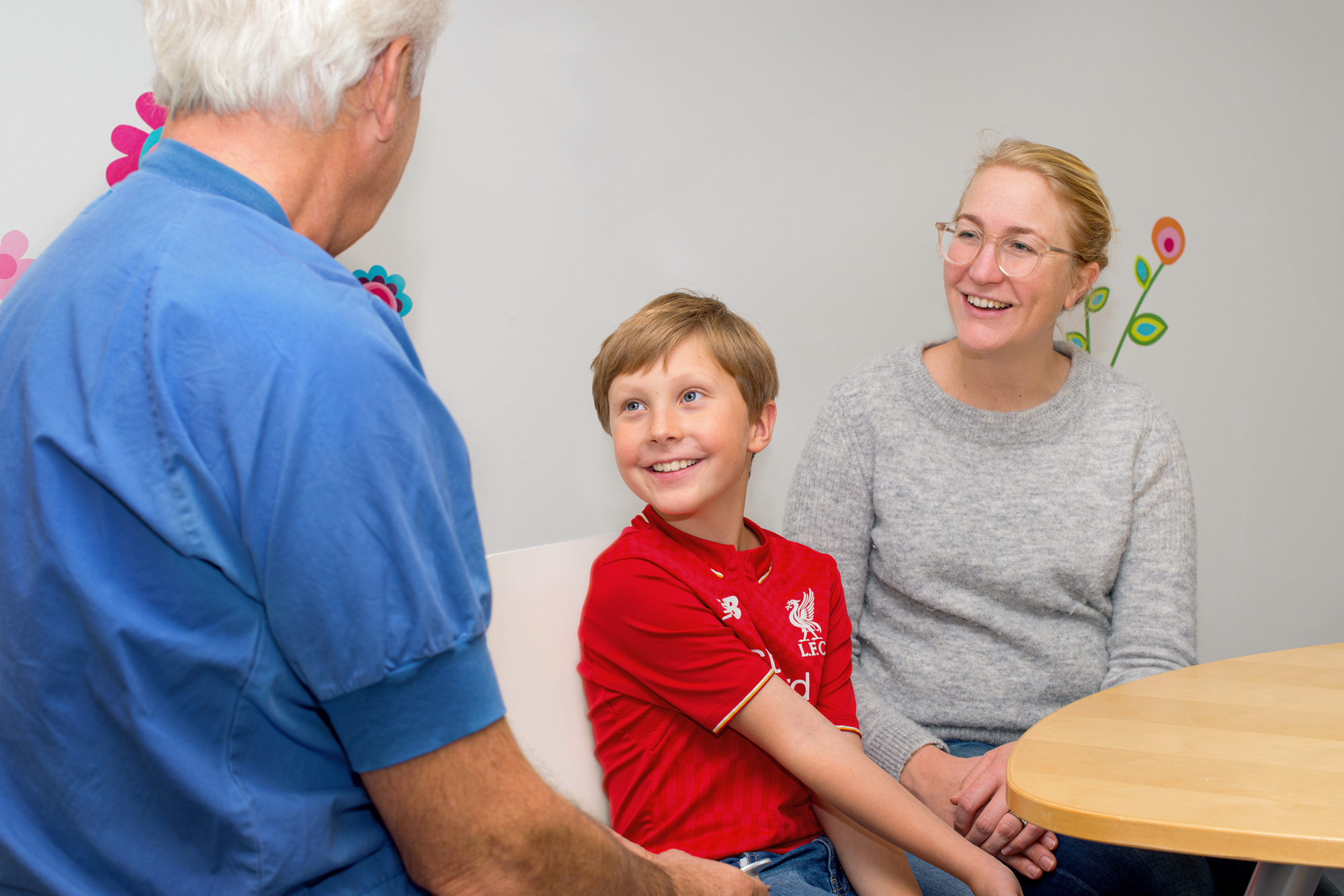 Boy and his mum are talking to doctor.