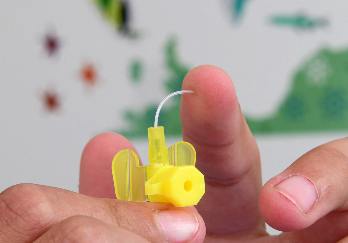 Close-up photo of the yellow thing, and the tube – which is really thin and bends when Frank’s fingers touch it.