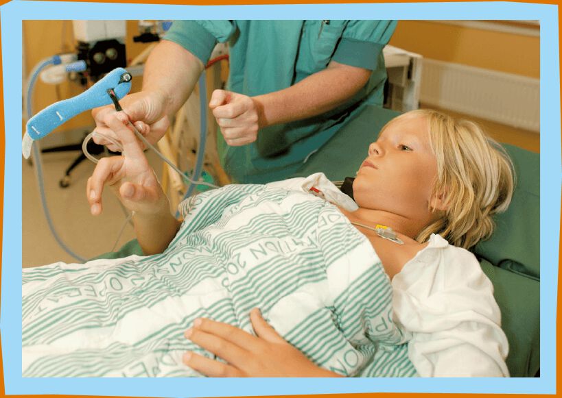 Nurse puts small blue lamp onto Lucas' finger.