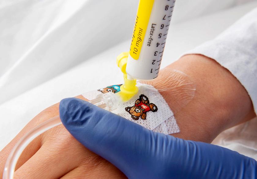 Nurse giving medicine with a syringe in a plastic tube.